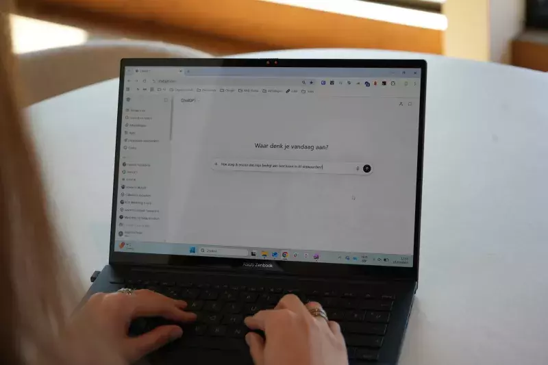 Vrouw typt op een laptop aan een wit tafelblad.